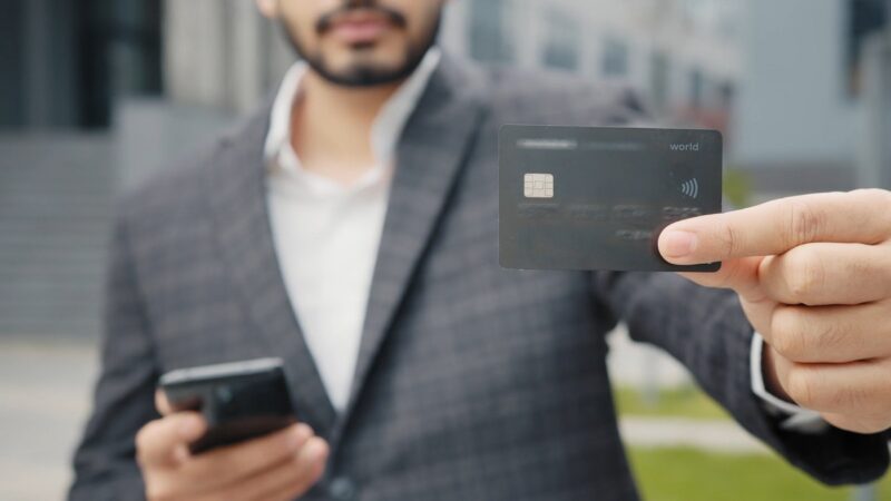 A guy holding a credit card in his hand