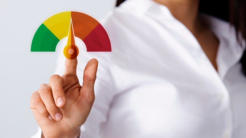 A woman in a white shirt touches a credit score gauge showing a medium credit level